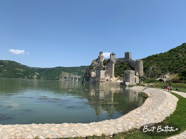A riverside castle with a clear view of the surrounding hills.