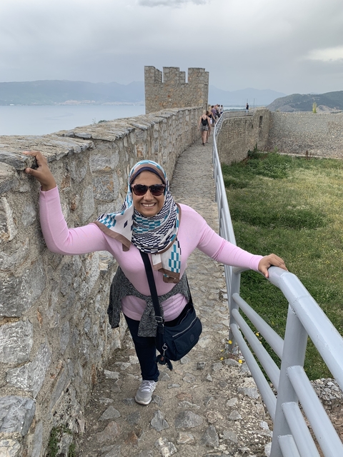       A woman posing and smiling on a stone path.
  