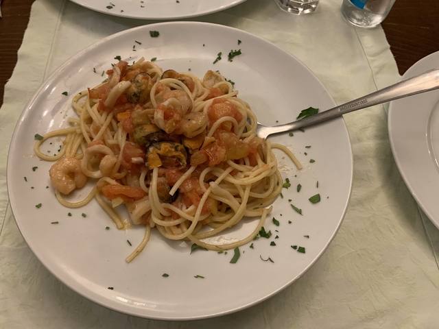       Plate of spaghetti with seafood in tomato sauce.
  