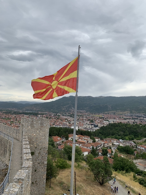       Macedonian flag waving with a city view in the background.
  