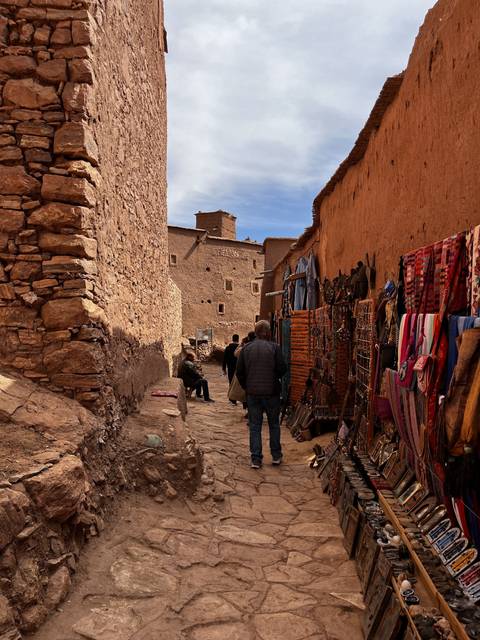       Narrow alley with small shops and people.
  