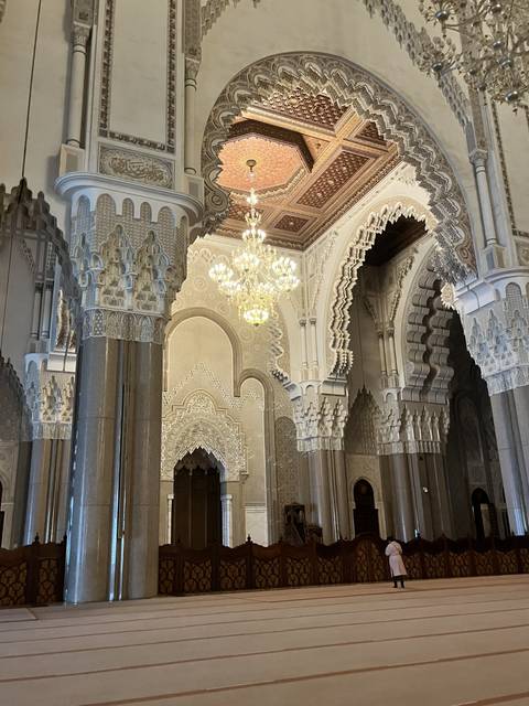       Intricate interior of a mosque with chandeliers.
  