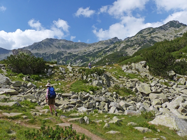       Backpackers hiking through rocky mountain landscape.
  