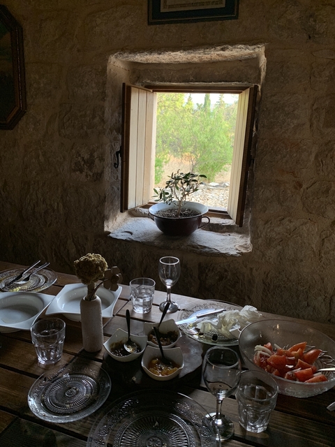 Interior of a rustic stone building with a table setting.