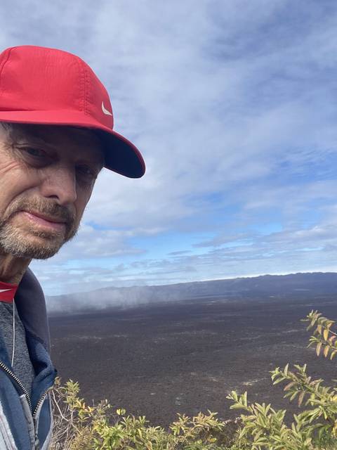 Selfie of a person with a volcanic landscape.