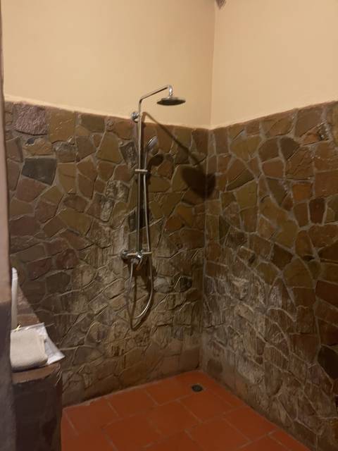 Shower area with stone wall.
