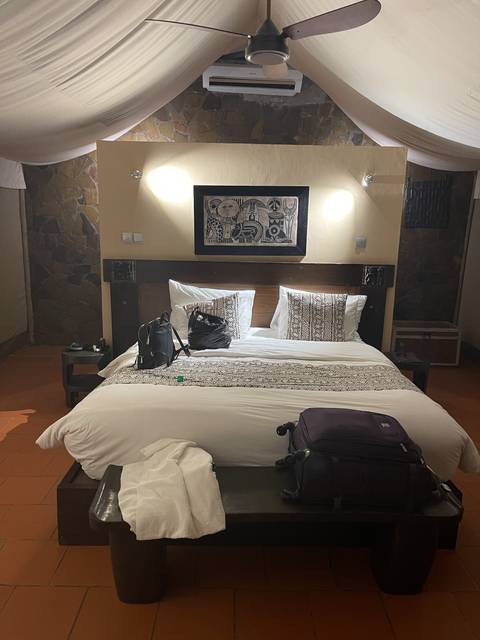       A bed with pillows and artwork.
  