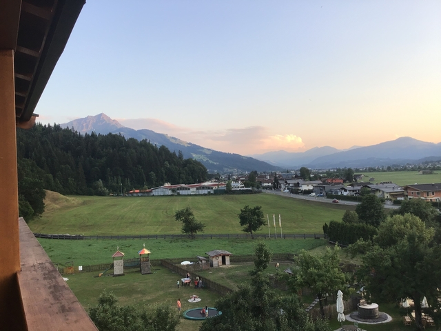 Panoramic view of a town nestled among mountains at sunset.