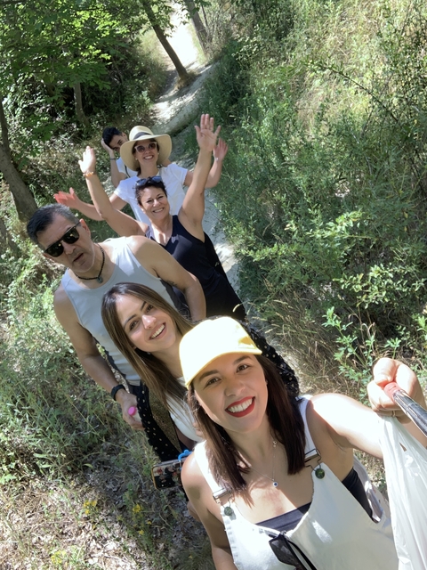 Group of people walking on a forest trail, taking a selfie.