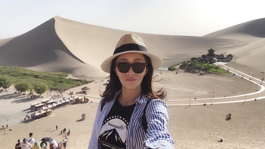 Person in front of sand dunes and a scenic area