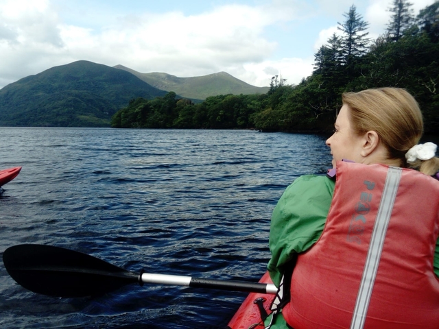       Woman kayaking on a lake.
  