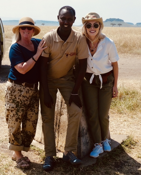       Three people posing together, possibly on a safari.
  