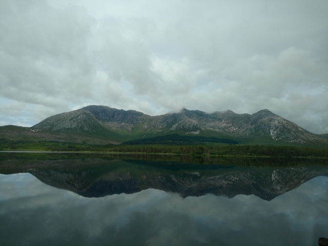 A mountain range reflected in a calm lake.