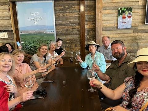 Group of people raising glasses in a winery.