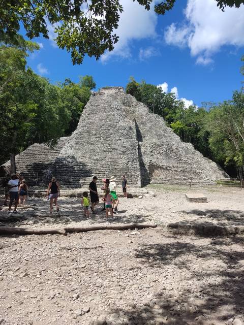 Tourists exploring ancient ruins in a jungle setting.