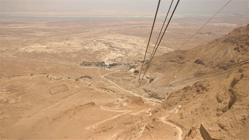 Aerial view of a desert with cable cars leading to a mountain