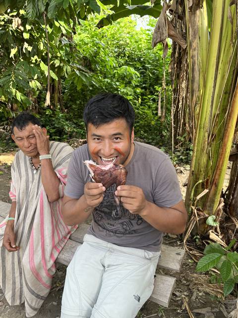 Person holding food in a natural setting.