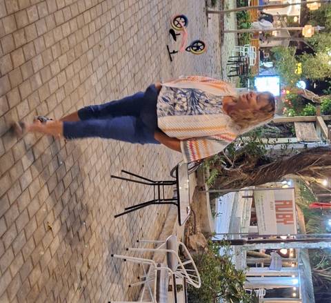 Person standing in an outdoor area with paving stones