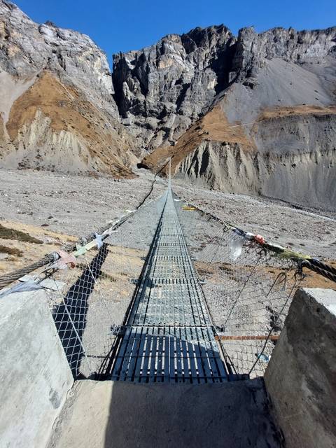       Suspension bridge over a rocky landscape.
  