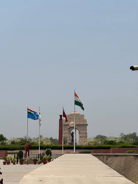       India Gate with flags in front.
  