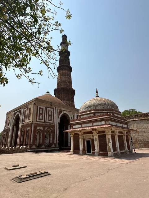 Qutub Minar with an adjacent mosque archway.