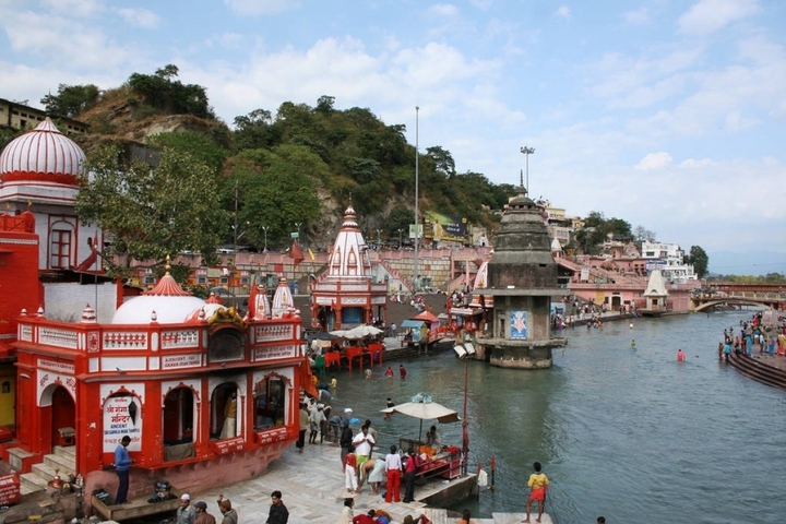 Haridwar waterfront with temples and people.