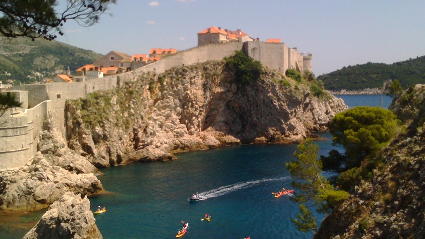 Rocky coastline with fortifications overlooking the sea.