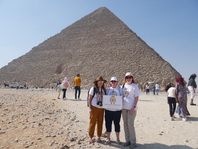       Group of people posing in front of the Pyramid of Giza.
  