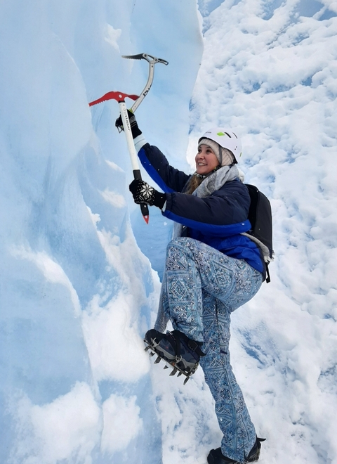 Person in ice gear climbing on a glacier.