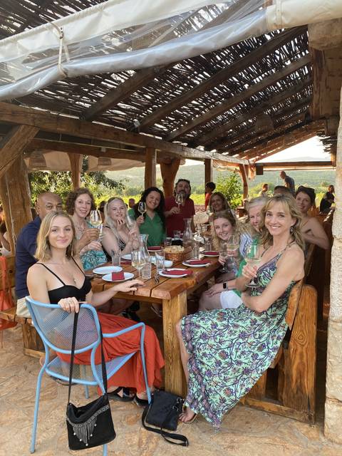 Group of people enjoying a meal and drinks outdoors.