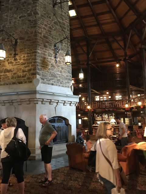       Rustic interior with stone fireplace and people.
  