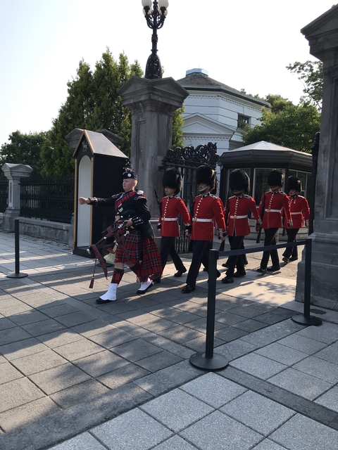      Ceremonial guards marching with a bagpiper.
  