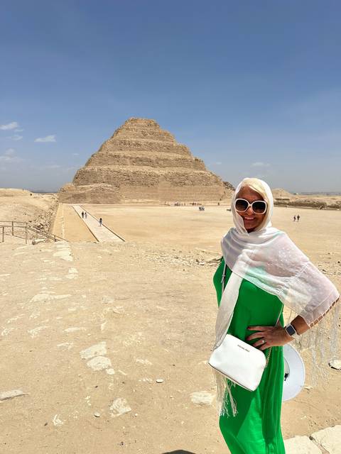       Woman posing in front of a step pyramid.
  