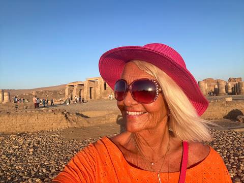 Woman posing upside down with ruins in the background.