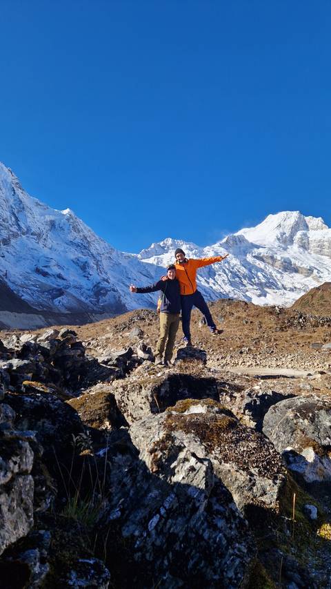 Two people posing with mountains in the background.