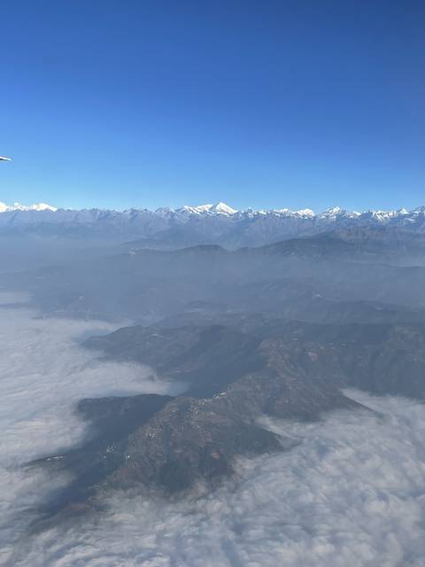 Aerial view of snow-capped mountains with clear blue sky.