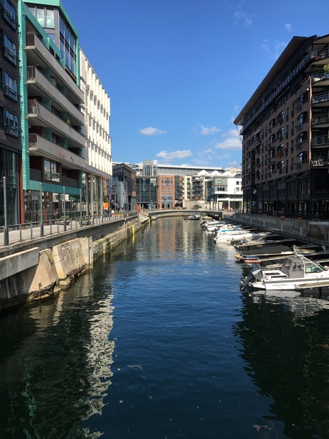 Modern waterfront area with boats and buildings.