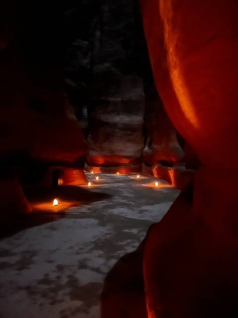       Candles illuminating a narrow canyon.
  