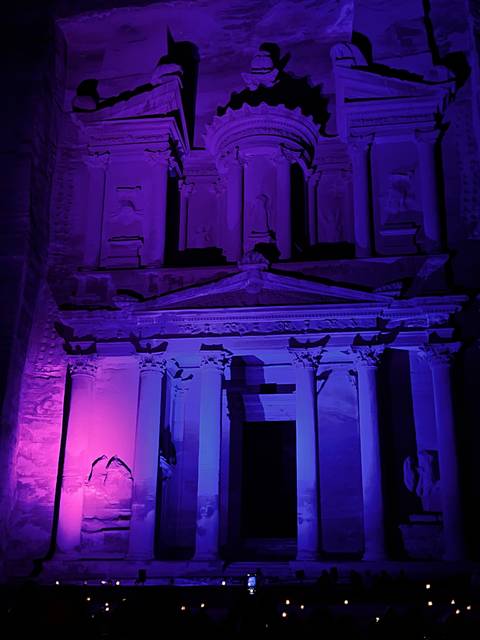       Petra Treasury lit in purple at night.
  
