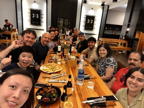       Group of people sitting around a large table with food.
  