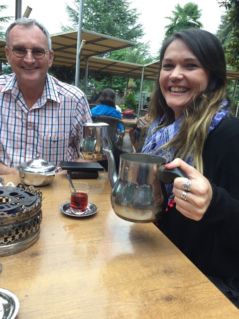 Two people enjoying tea at an outdoor setting.