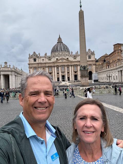       Couple posing in front of St. Peter's Basilica.
  