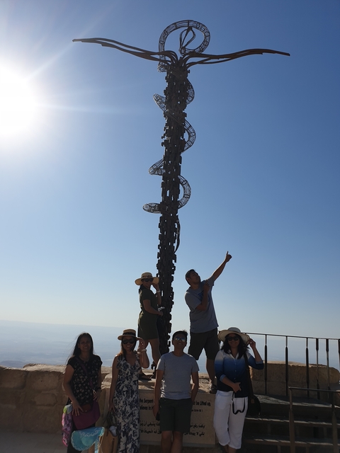 Statue with two people, one pointing at the sky.