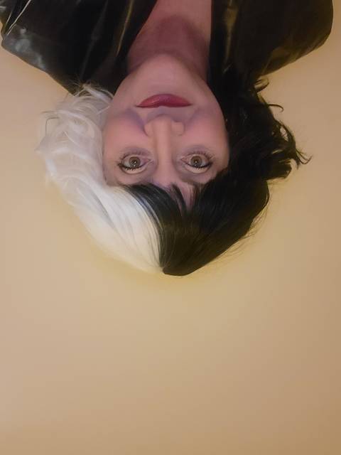 Close-up portrait of a person wearing a Cruella de Vil wig.