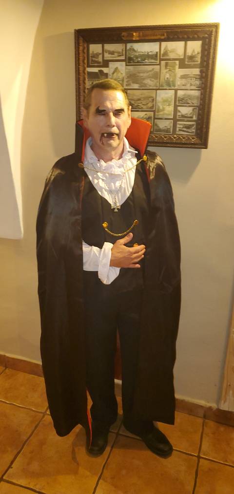       Person in a vampire costume posing indoors.
  
