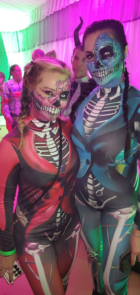 People in skeleton costumes with face paint at an event.