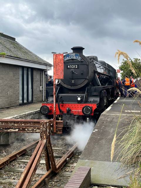 Steam locomotive stopped at a station platform.