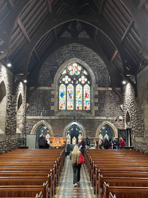 Interior of a stone church with stained glass windows.