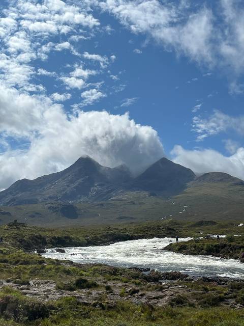 Flowing river with mountains in the background.