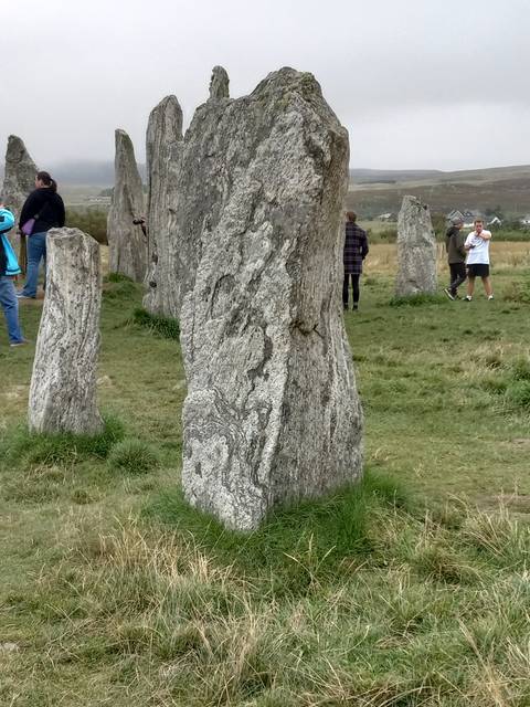 Standing stones with a person walking nearby.